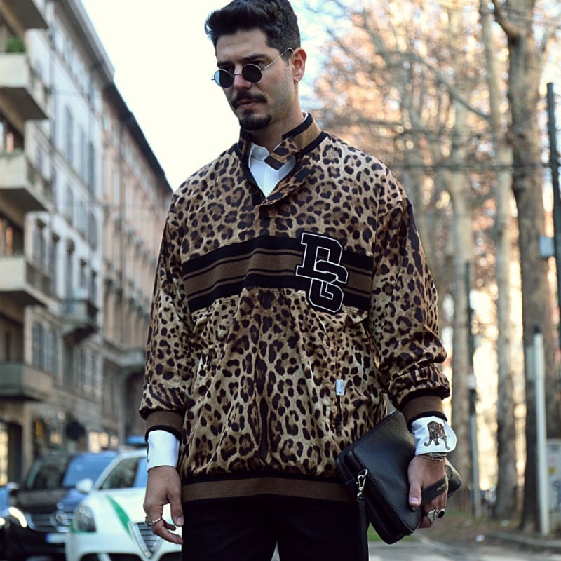 мужчина в кофте с леопардовым принтом гуляет по городу