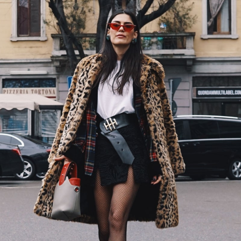 женщина в леопардовом пальто гуляет по городу