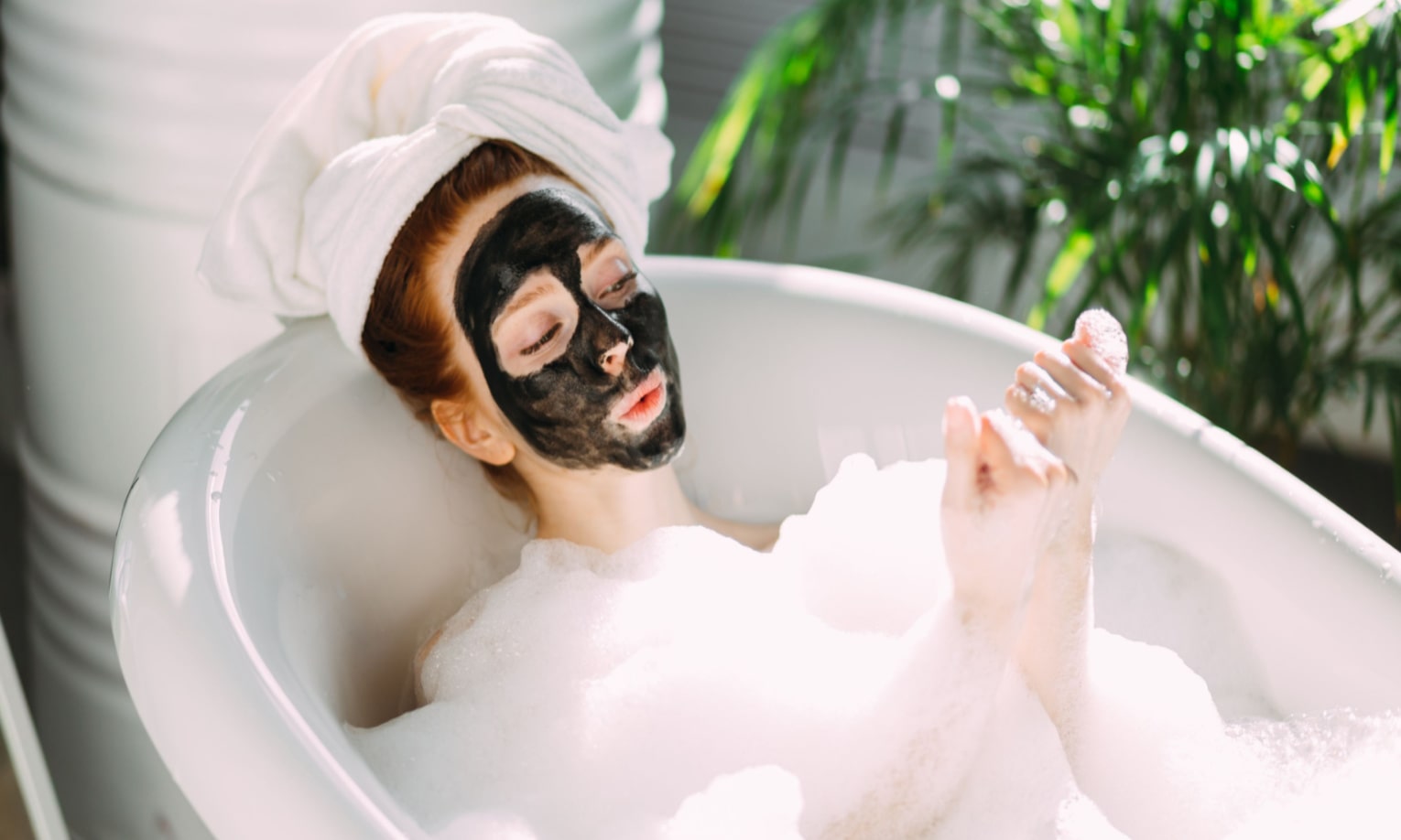девушка с маской для лица лежит в ванной
