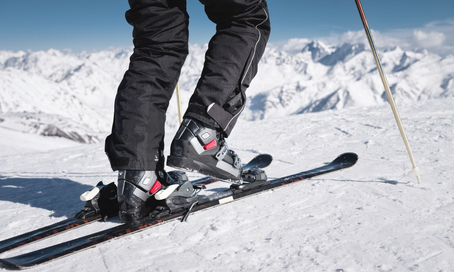ноги лыжника фиксированы лыжными креплениями