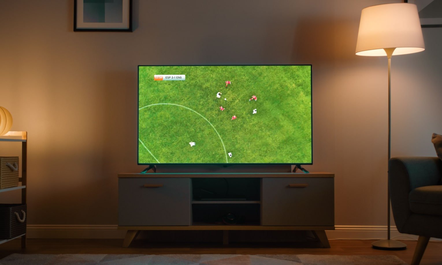 телевизор с изображением футбольного поля на комоде
