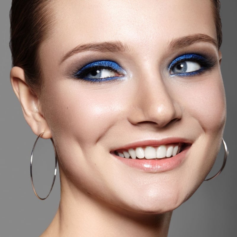 naeratav naine sinise silmameigiga