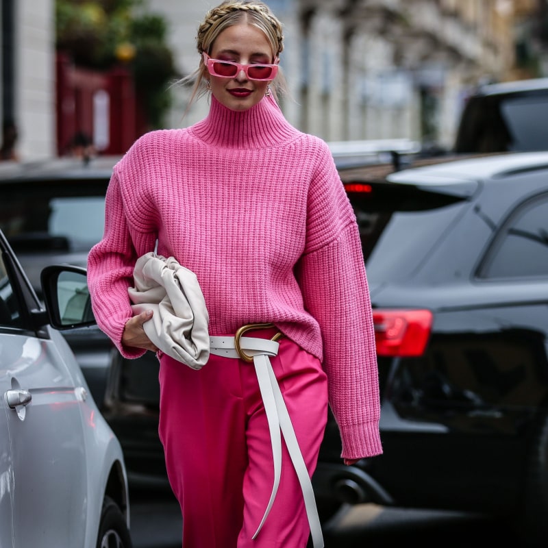 женщина в розовом наряде гуляет по городу