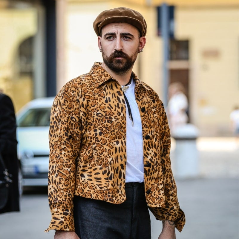 мужчина в леопардовой куртке гуляет по городу