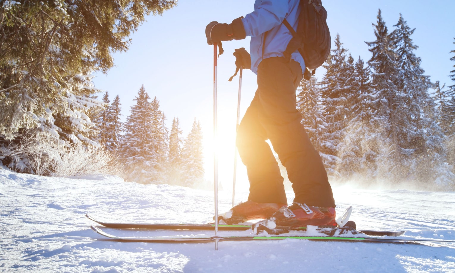 мужчина с лыжными палками в руках катается на лыжах