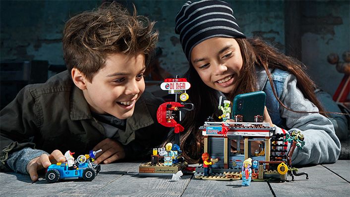 мальчик и девочка играют с конструктором LEGO Hidden Side - потерпевший кораблекрушение