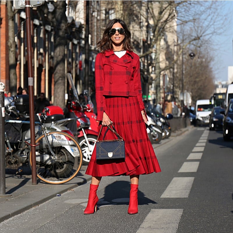moteris su raudonos spalvos drabuziais gatveje