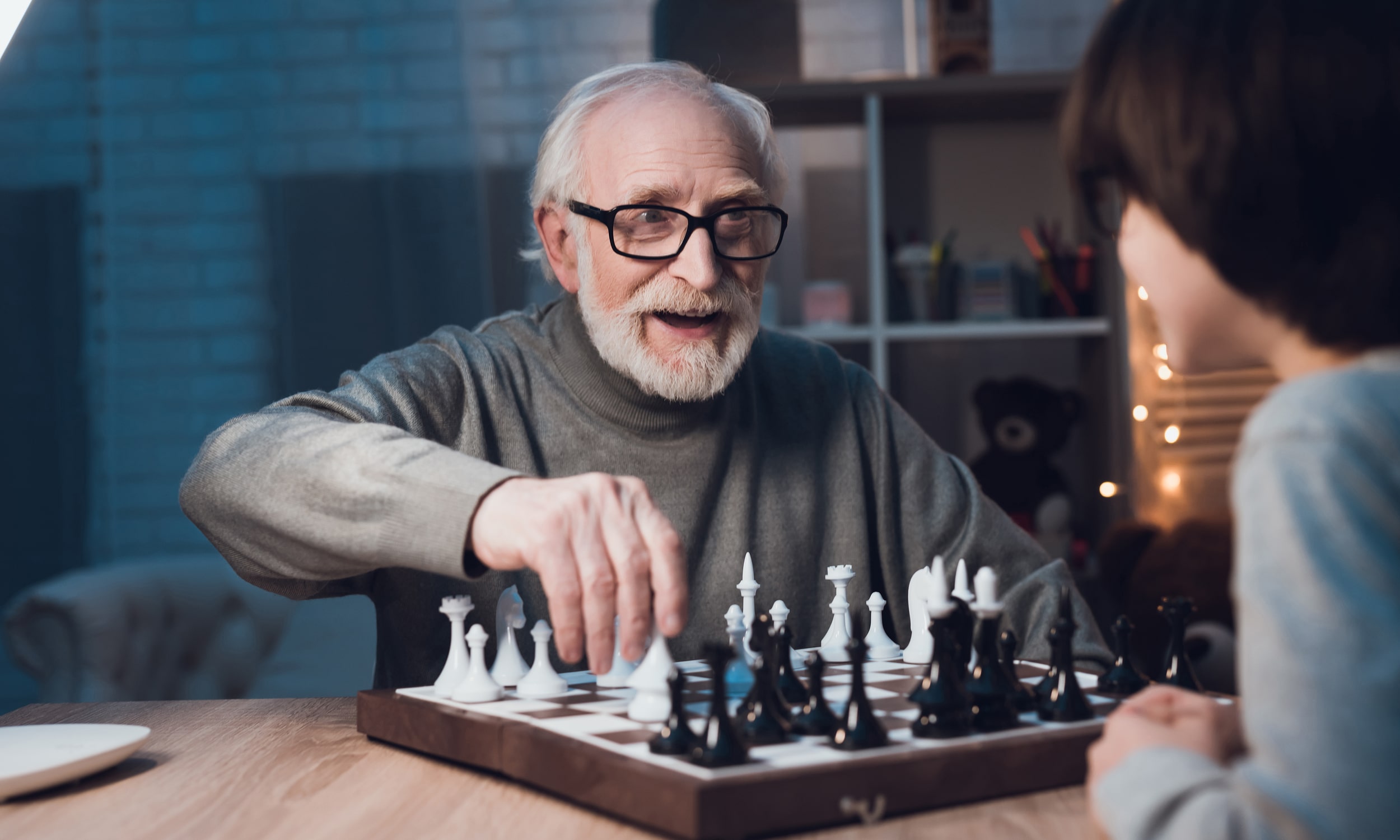 дедушка с внуком играют в шахматы