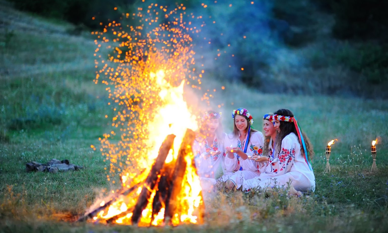 meitenes sez pie ugunskura