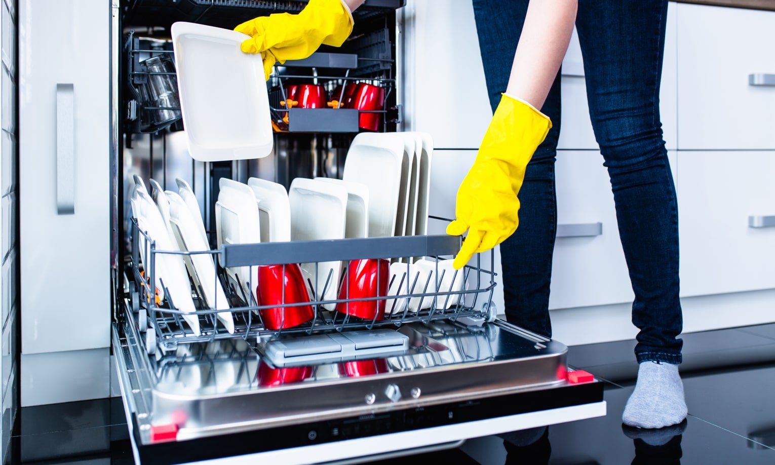 женщина загружает посуду в посудомоечную машину electrolux ees42210l
