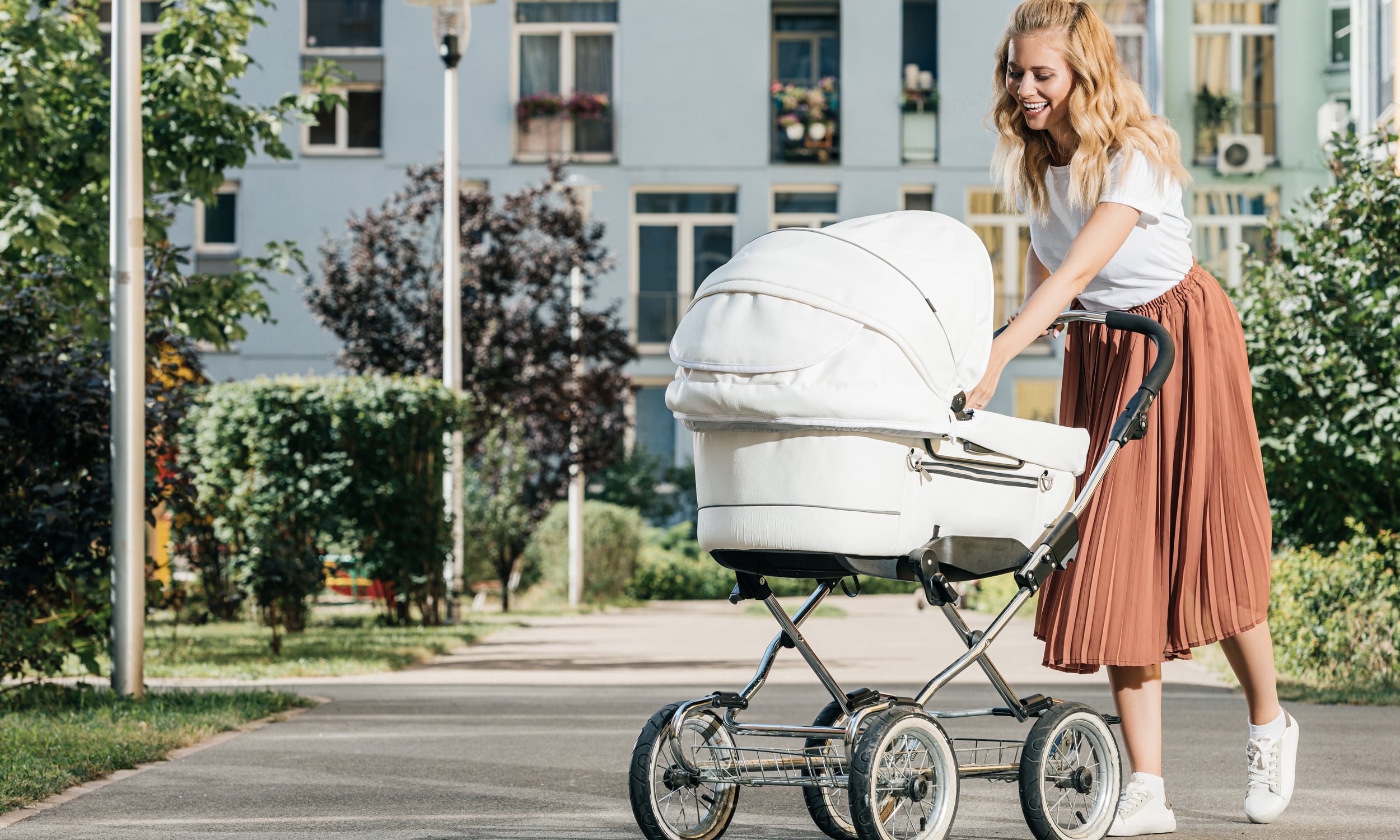 мама с малышом гуляет в парке с коляской