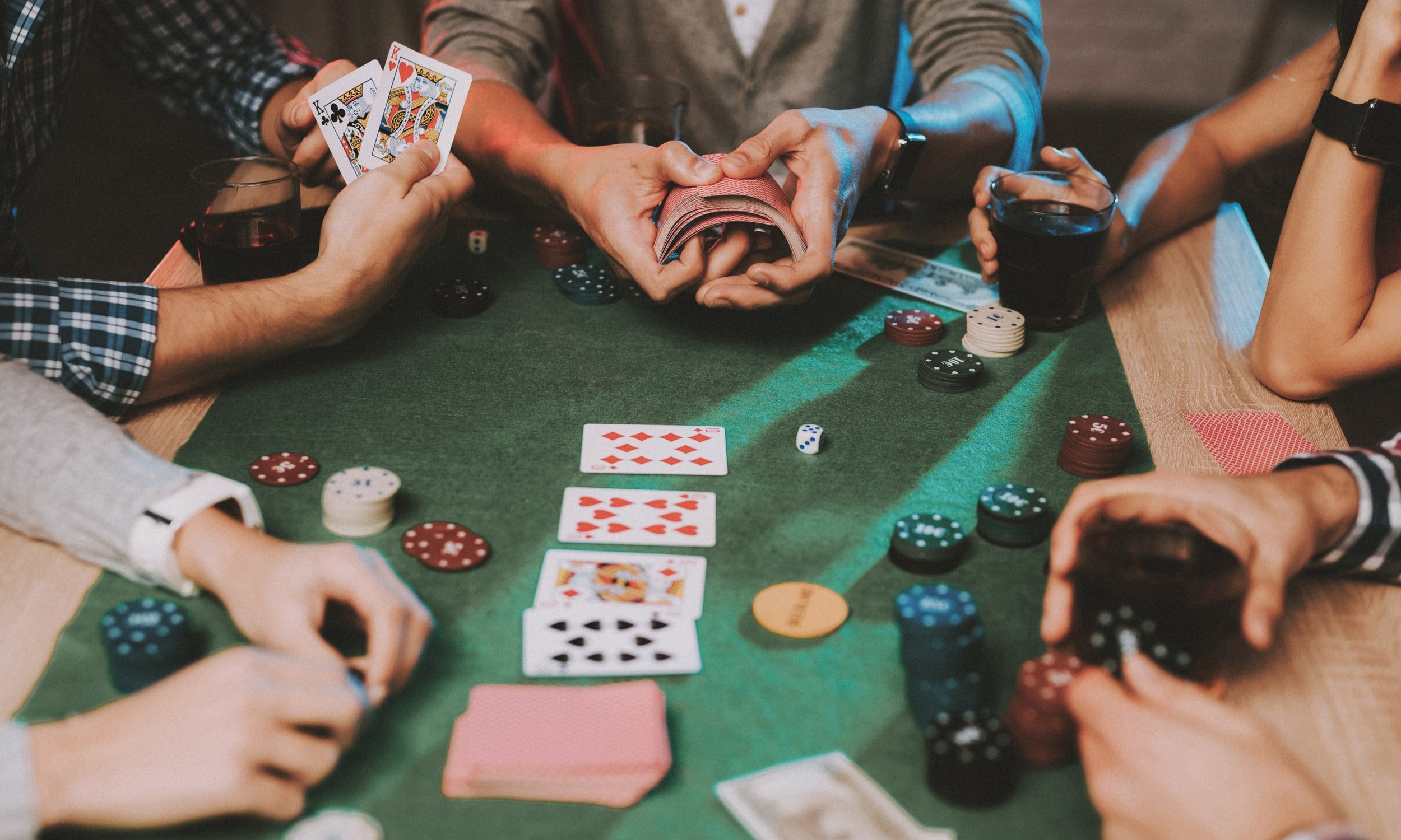 zmones zaidzia pokeri prie stalo su kortomis ir zetonais
