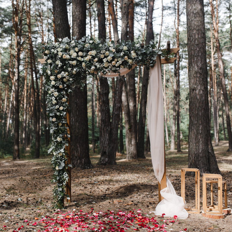 деревянная арка для свадьбы во дворе, украшенная цветами и материалами