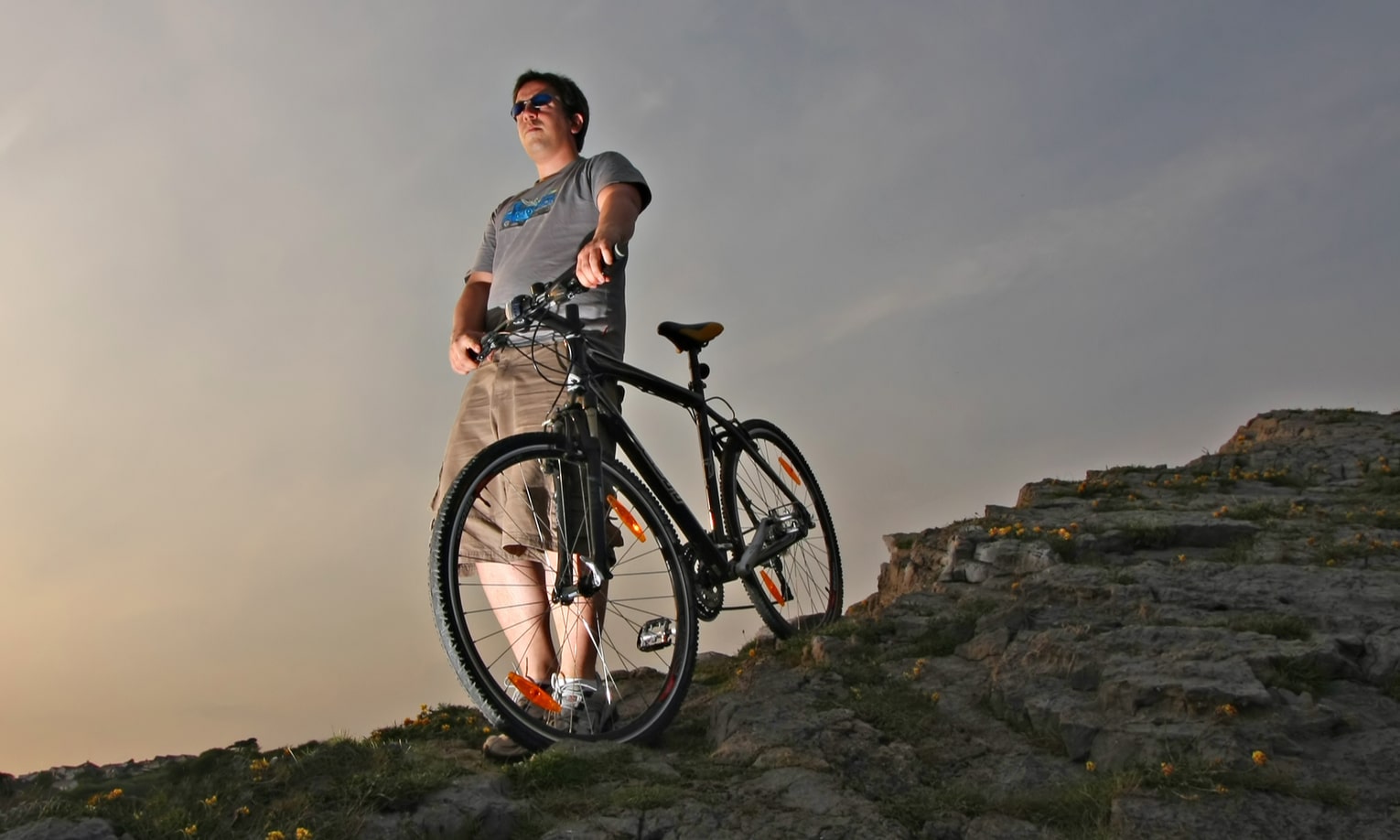 мужчина в горах с гибридным велосипедом
