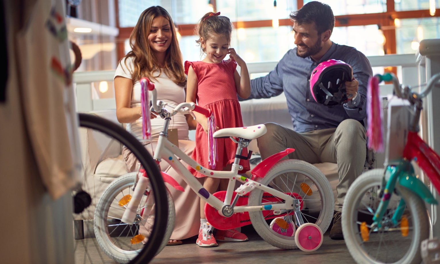 девочка с родителями выбирают велосипед