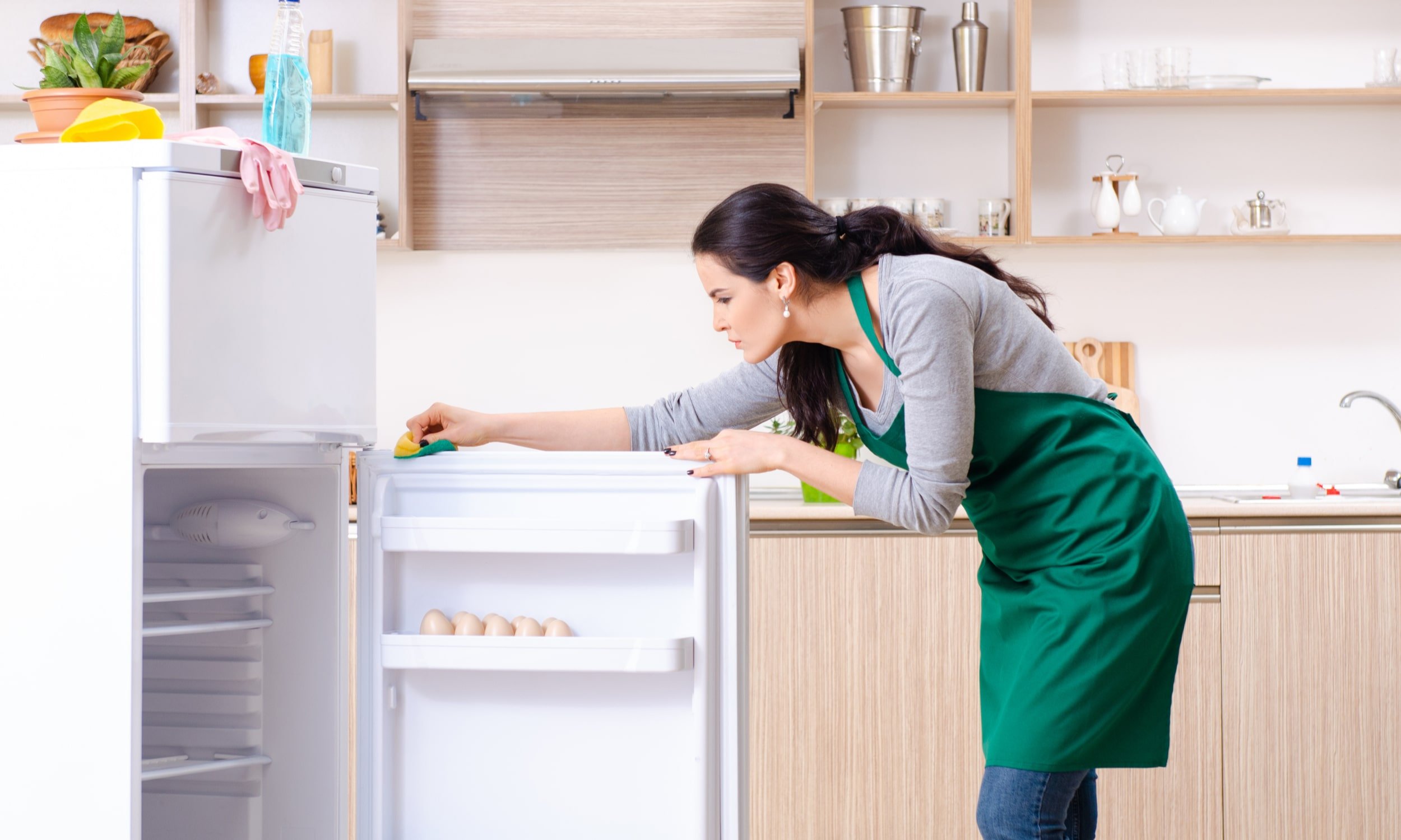 sieviete tira ledusskapi iekspuse