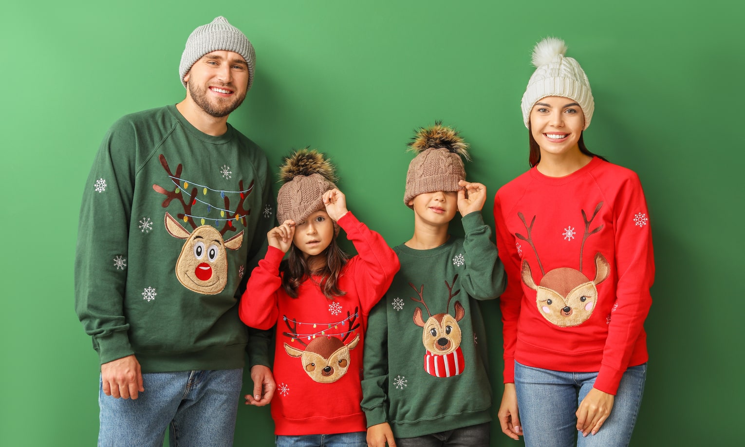 семья в рождественских свитерах красного и зеленого цвета