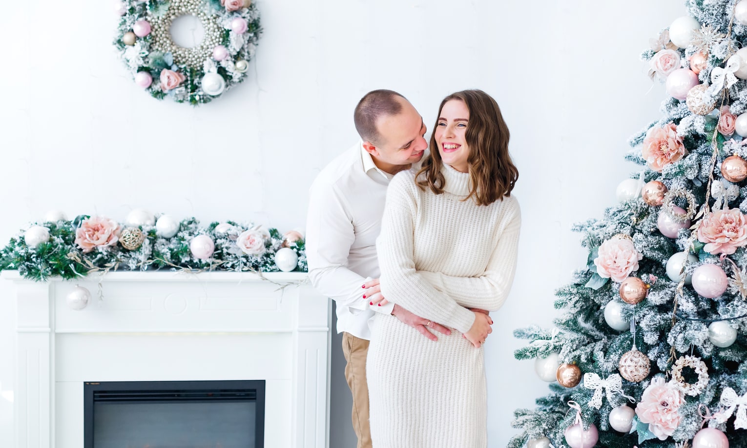 мужчина и женщина в белой рождественской одежде у елки