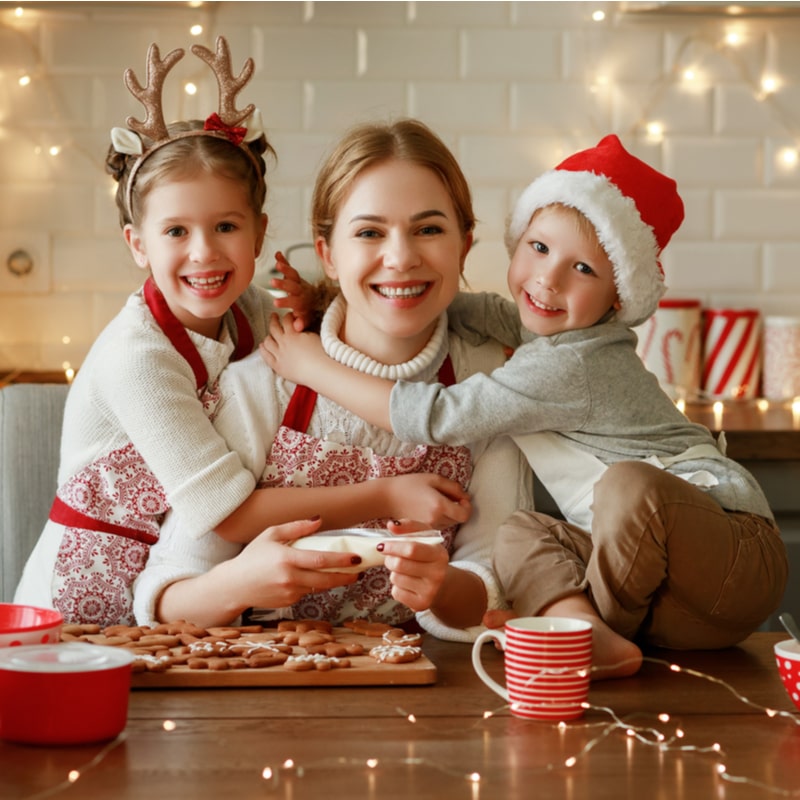 мама с детьми в рождественских свитерах и фартуках