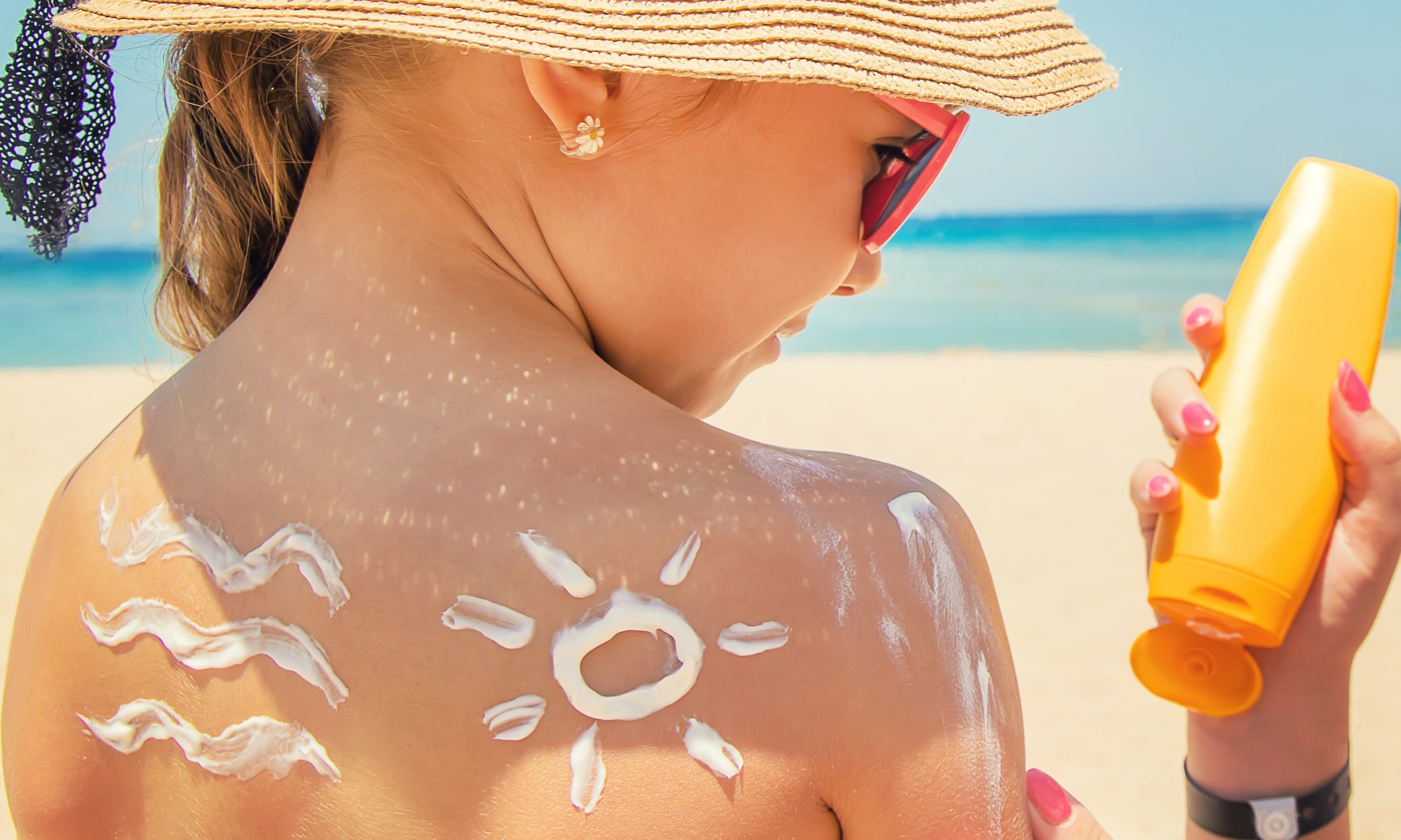 девочка пользуется солнцезащитным кремом