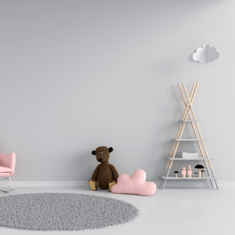minimalistlik laste mänguruum ruumis, kus on mitu mänguasja ja riiul