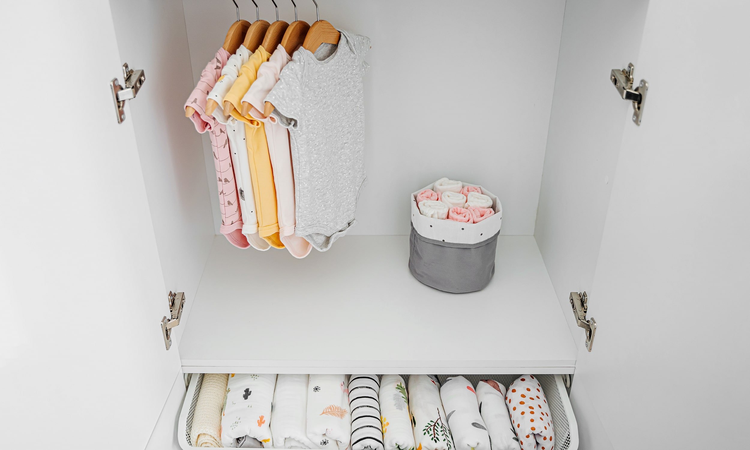 одежда для новорожденных сложенная в шкафу