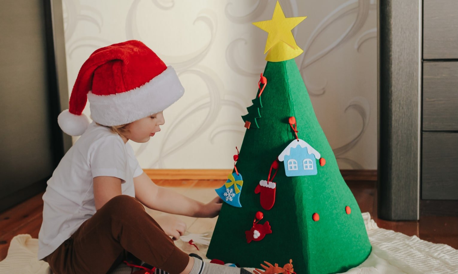 laps kaunistab jõulupuud vildist kaunistustega