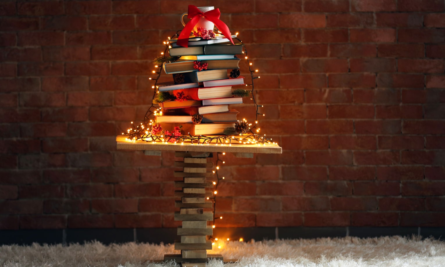 елочка из книг украшена лампочками