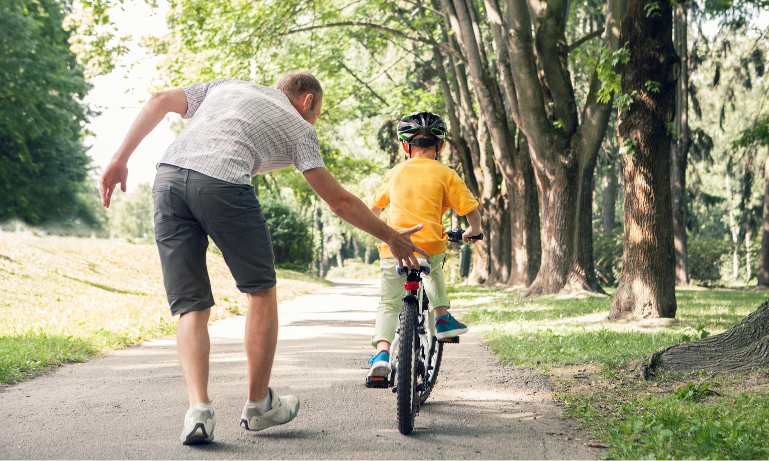 isa õpetab poega jalgrattaga sõitma