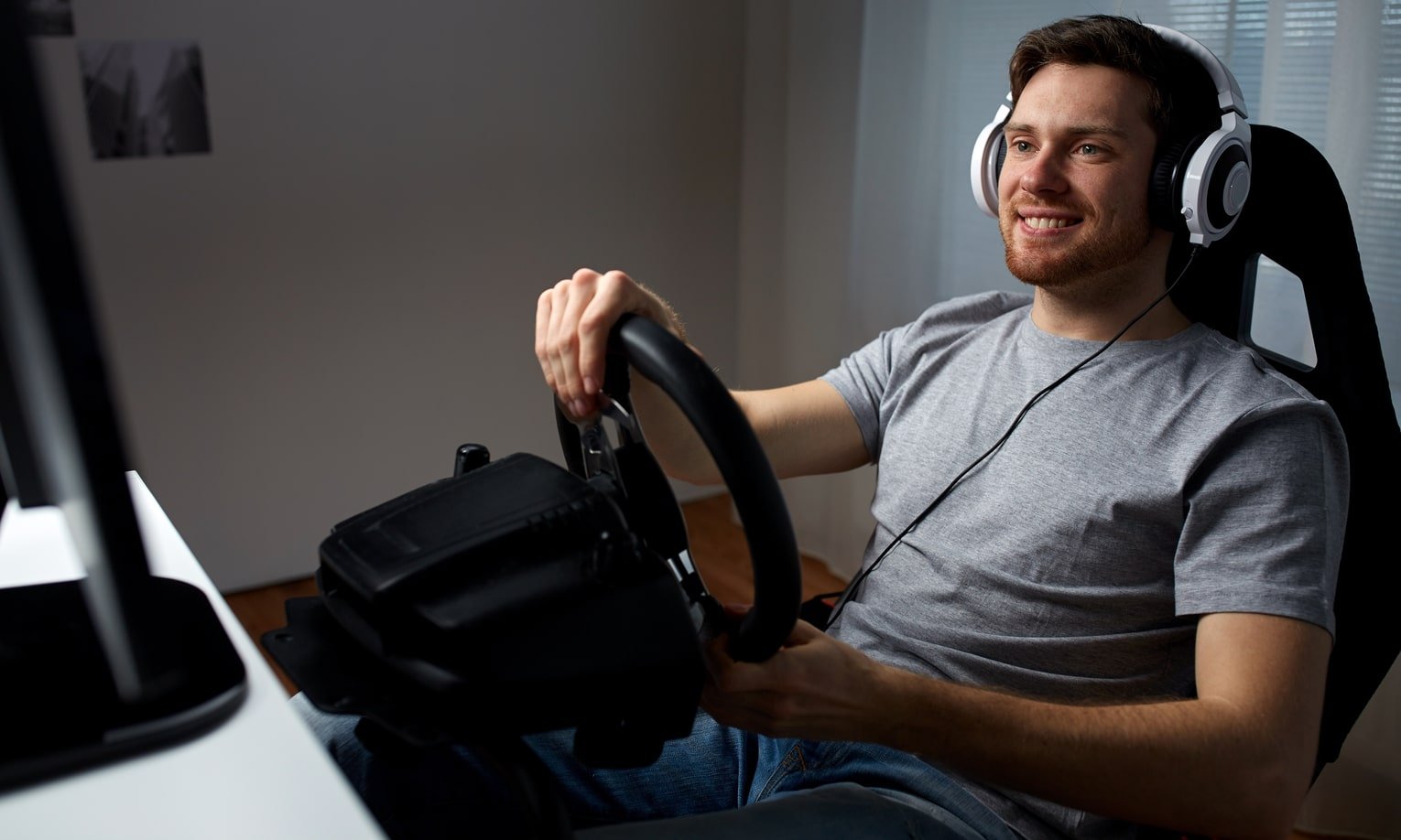 мужчина играет в компьютерную игру с рулем