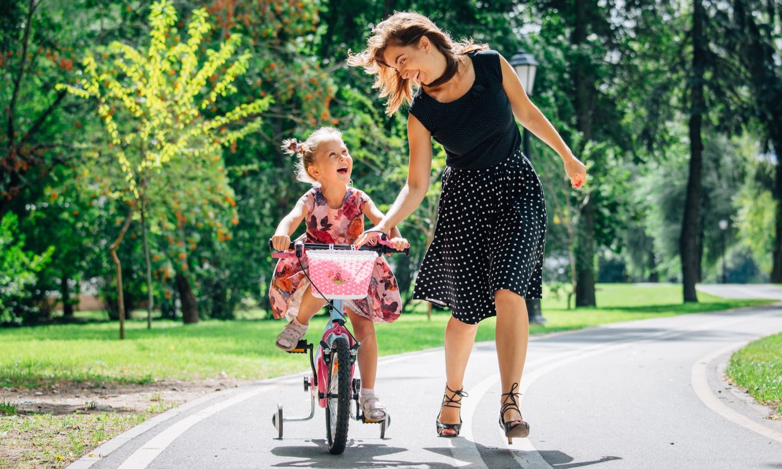 ema õpetab tütart jalgrattaga sõitma