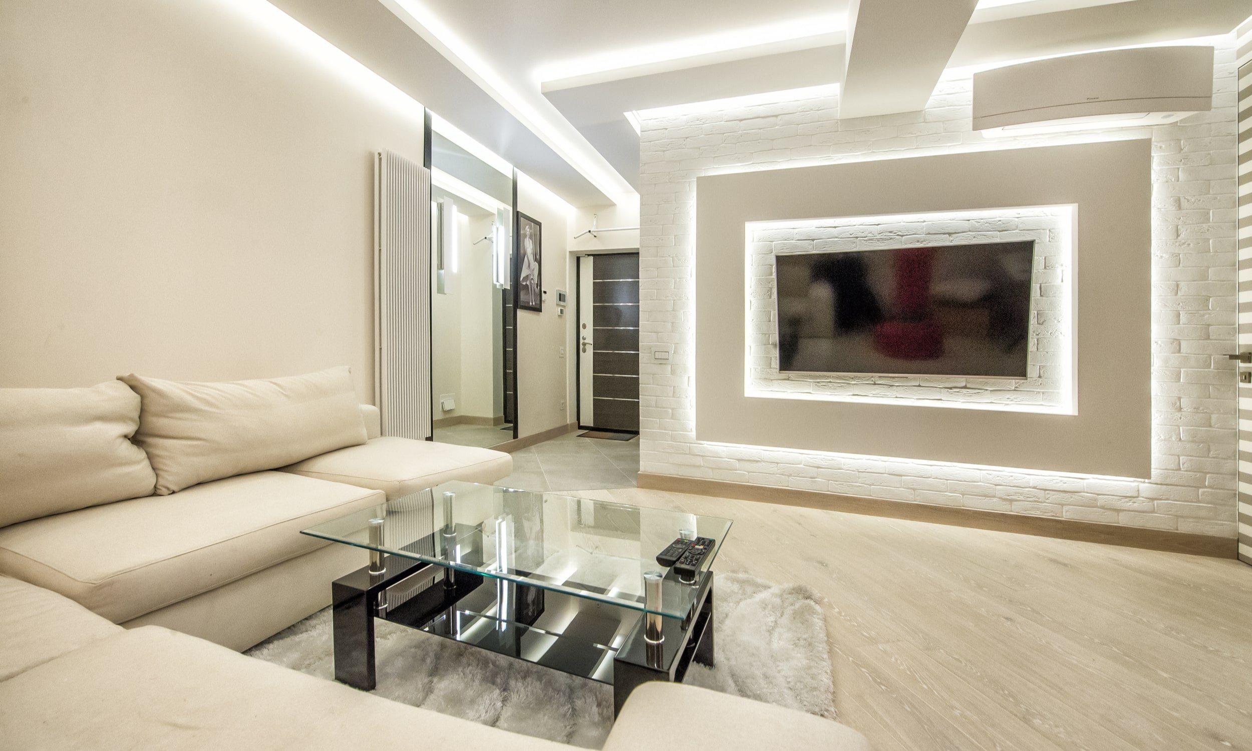 kaasaegne ja avar elutuba, kus LED-ribad on laes ja seinal teleri taga