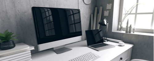 большой монитор в домашнем пространстве на офисном столе рядом с ноутбуком