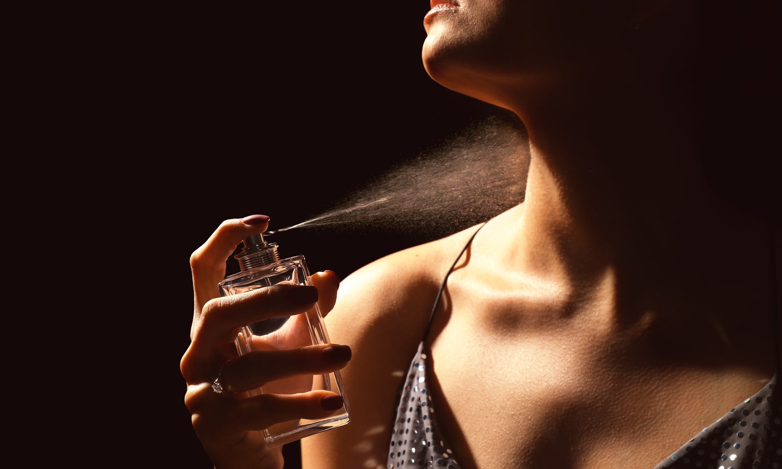 naine piserdab kaelale parfüümi