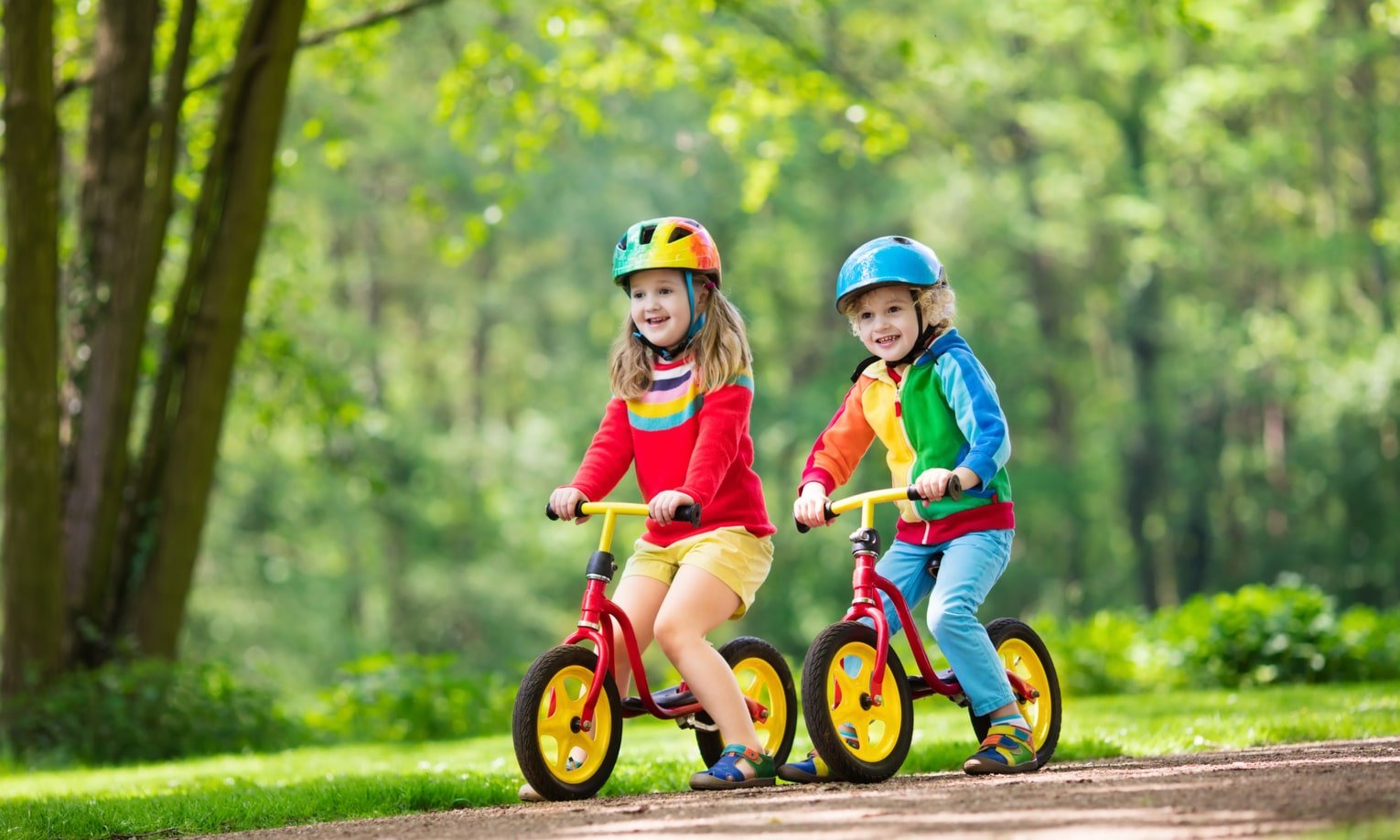 berniukas su mergaite vaziuoja balansiniais dviraciais parke