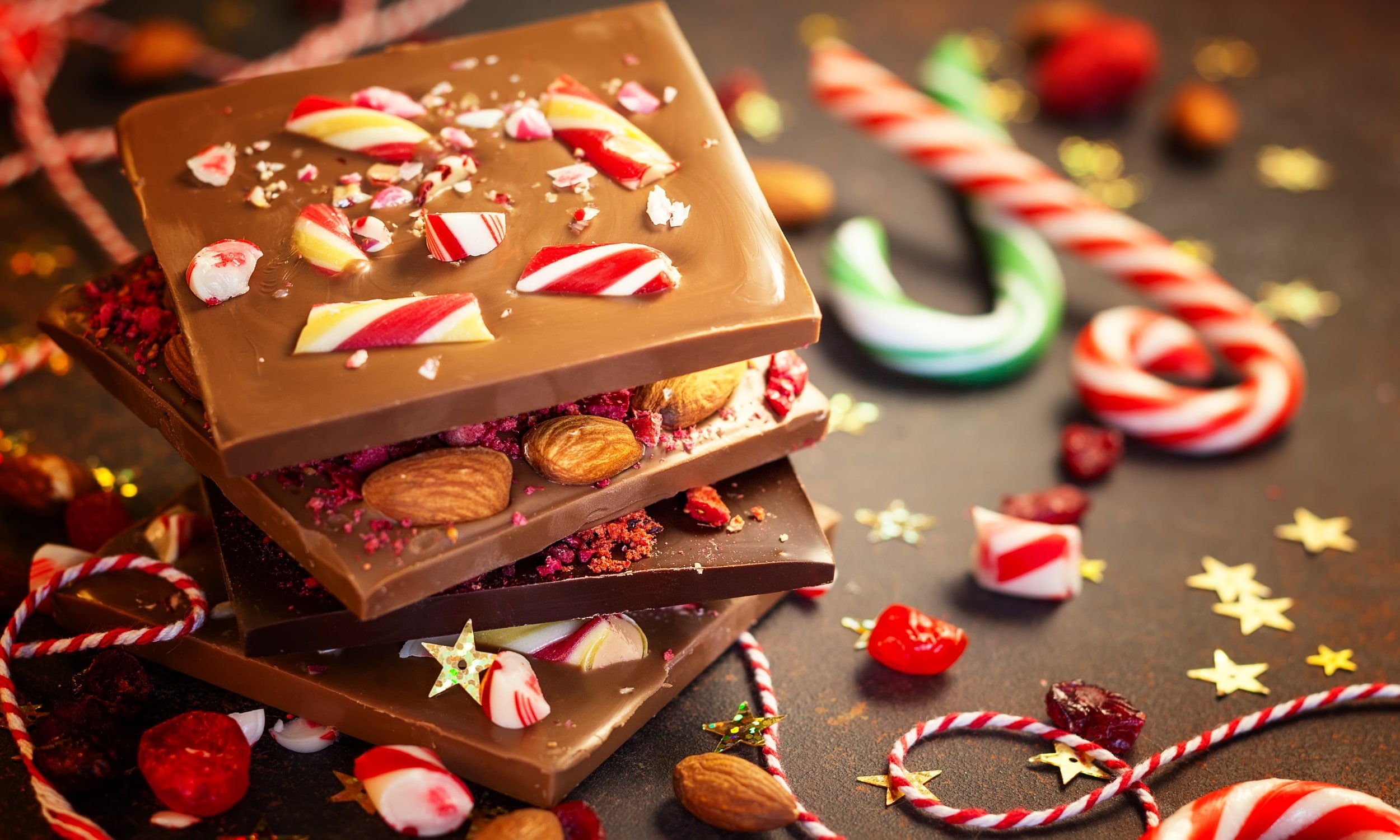 кусочки шоколада и сахарные палочки в рождественской тематике